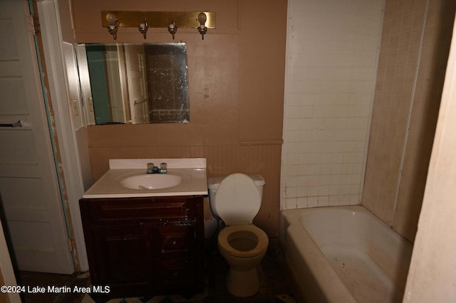 bathroom with a tub, vanity, and toilet