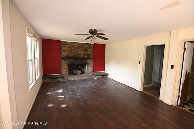 unfurnished living room featuring ceiling fan, dark hardwood / wood-style floors, and a brick fireplace