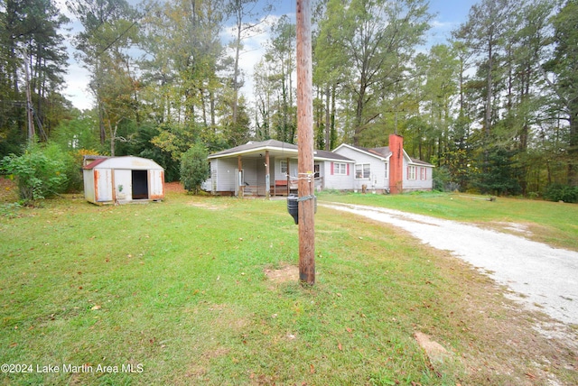 view of front of house with a storage unit, a porch, and a front lawn