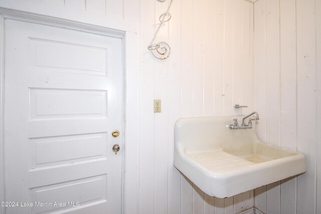 bathroom with wooden walls and sink