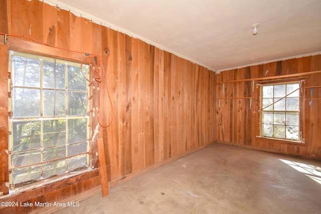 empty room with concrete floors and wood walls