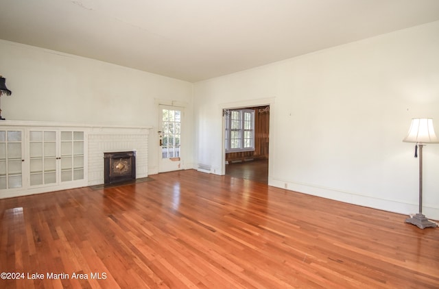 unfurnished living room with hardwood / wood-style flooring, crown molding, and a fireplace