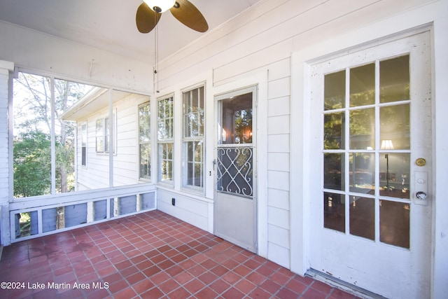 unfurnished sunroom with ceiling fan