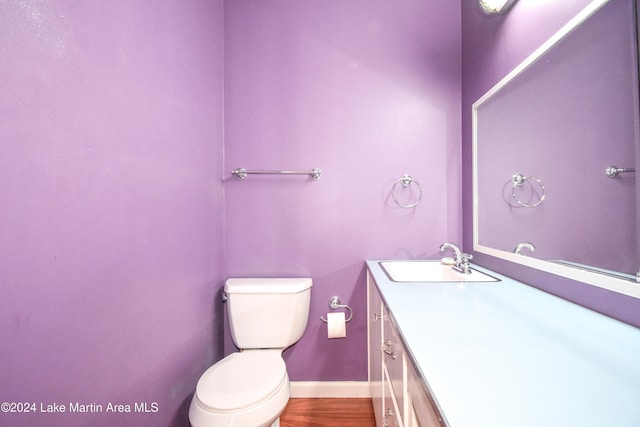 bathroom with hardwood / wood-style floors, vanity, and toilet