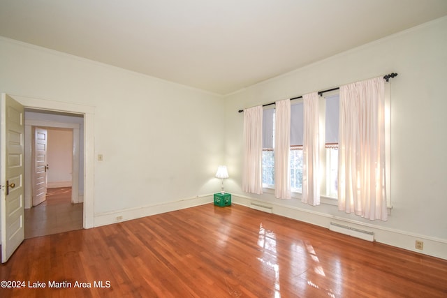 empty room with crown molding and hardwood / wood-style floors