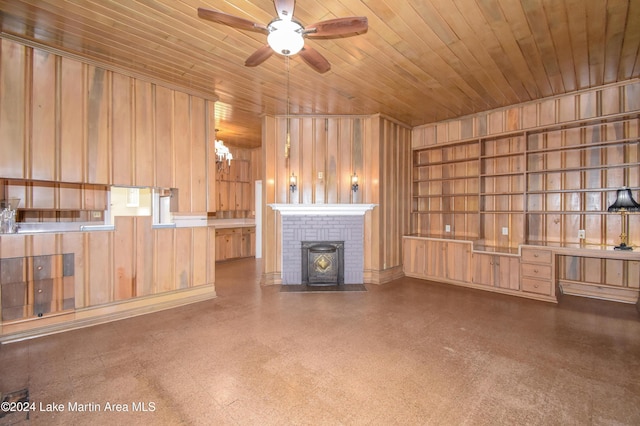 unfurnished living room featuring ceiling fan with notable chandelier, wood walls, and wood ceiling