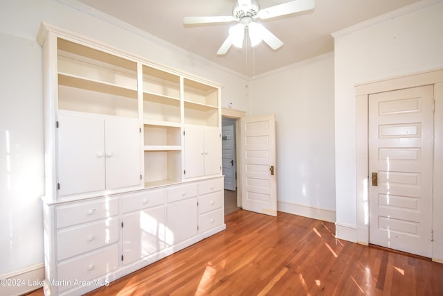 unfurnished bedroom with wood-type flooring, a closet, ceiling fan, and ornamental molding