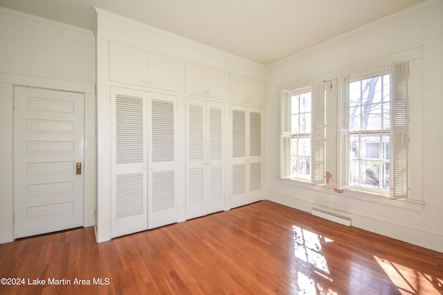 unfurnished bedroom featuring hardwood / wood-style floors and crown molding