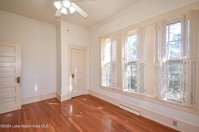 unfurnished room with dark hardwood / wood-style floors, a wealth of natural light, crown molding, and ceiling fan