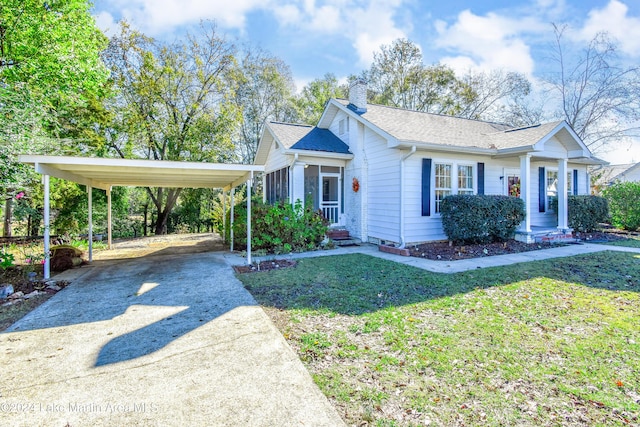 view of front of property with a sunroom, a front lawn, and a carport