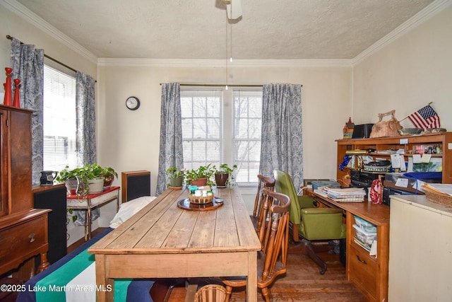 dining area with a textured ceiling, wood finished floors, and ornamental molding