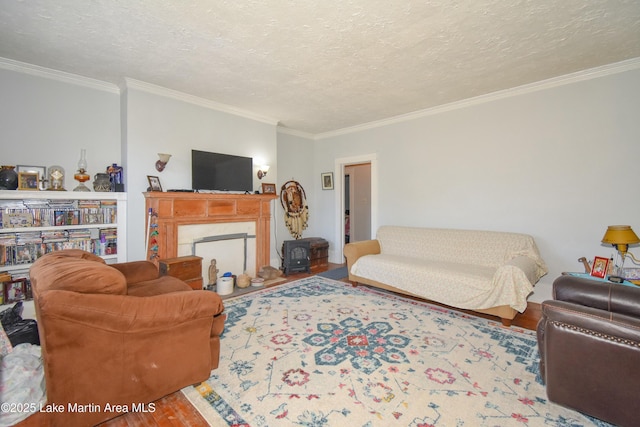 living area with a textured ceiling, wood finished floors, and ornamental molding