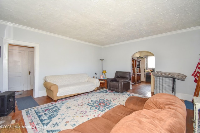 living area featuring arched walkways, a textured ceiling, wood finished floors, and a wood stove