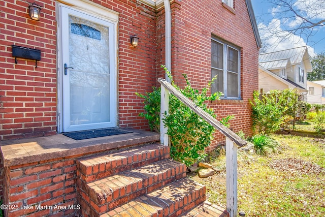 entrance to property featuring brick siding