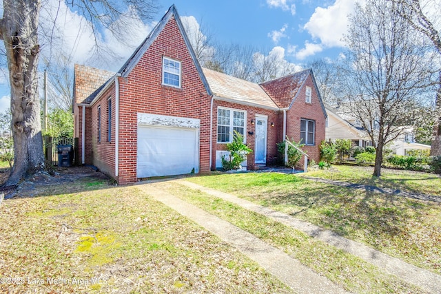 view of front facade featuring a garage, a front lawn, brick siding, and driveway