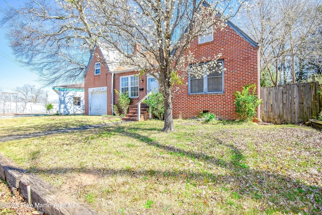view of front facade featuring brick siding, a front yard, and fence