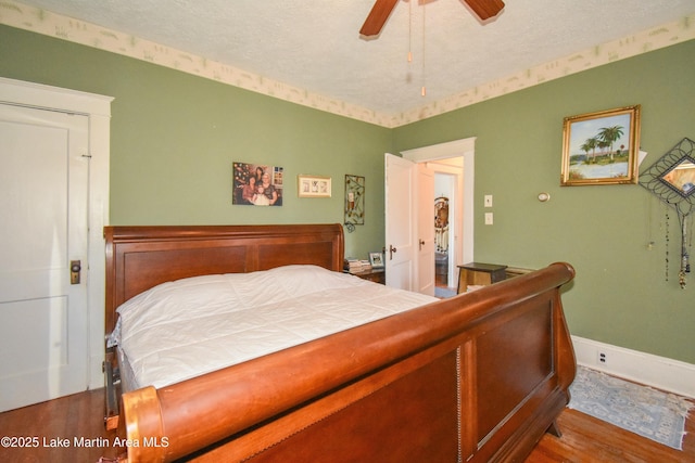 bedroom with baseboards, a textured ceiling, wood finished floors, and a ceiling fan