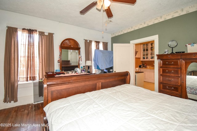 bedroom with multiple windows, a textured ceiling, and wood finished floors