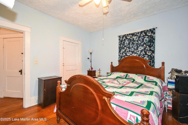bedroom featuring ceiling fan, a textured ceiling, and wood finished floors