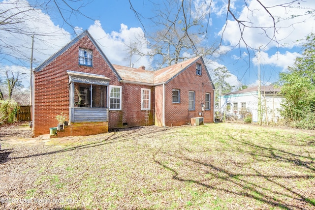 exterior space with a front yard, central AC unit, and brick siding