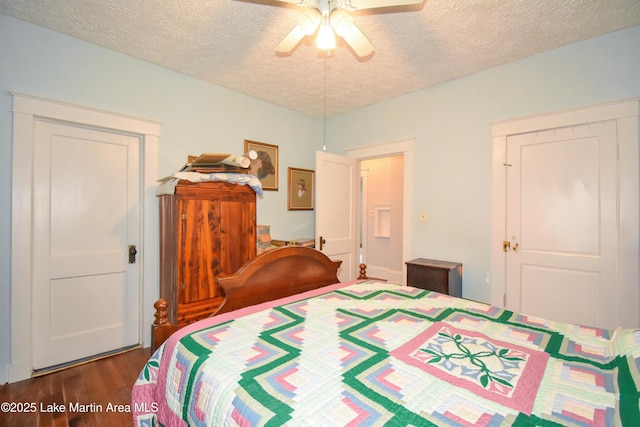 bedroom with ceiling fan, wood finished floors, and a textured ceiling