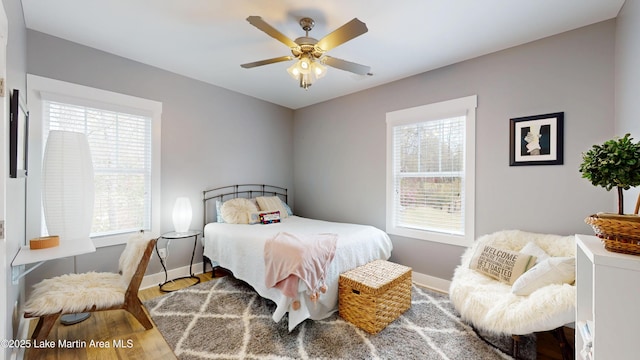 bedroom with baseboards, ceiling fan, and wood finished floors