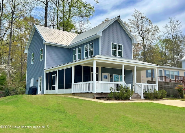 country-style home featuring a front lawn, metal roof, and a porch