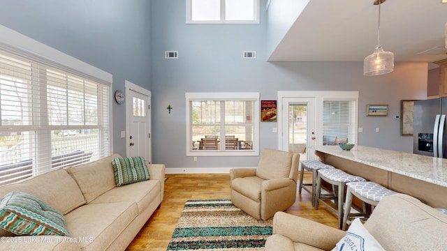 living area with a wealth of natural light, visible vents, and light wood-style floors