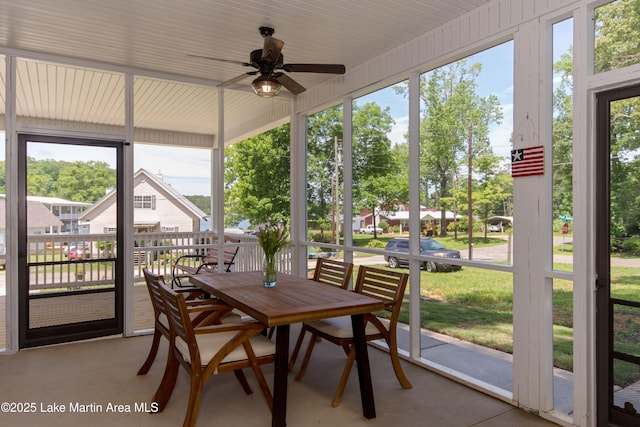sunroom with outdoor dining area and a ceiling fan