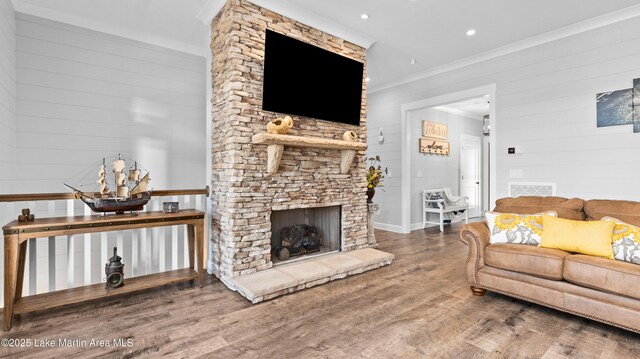 101 Mason Rd, Tallassee, AL 36078 - living room with wood walls, wood finished floors, ornamental molding, visible vents, and a stone fireplace