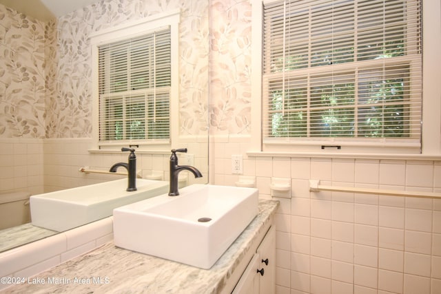 bathroom featuring vanity and tile walls