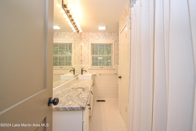 bathroom featuring tile patterned flooring, vanity, and tile walls