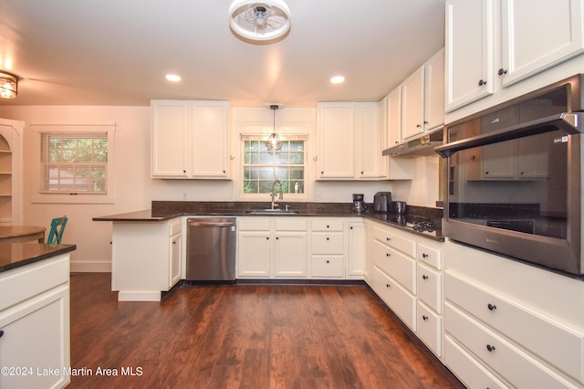 kitchen with sink, white cabinetry, hanging light fixtures, and black appliances