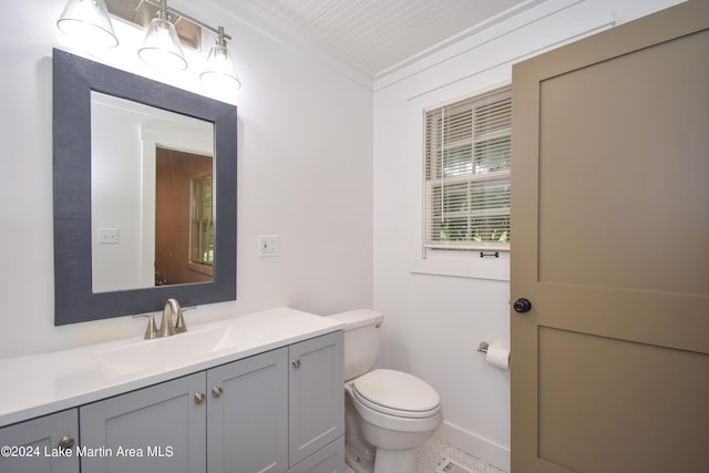 bathroom with vanity, ornamental molding, and toilet