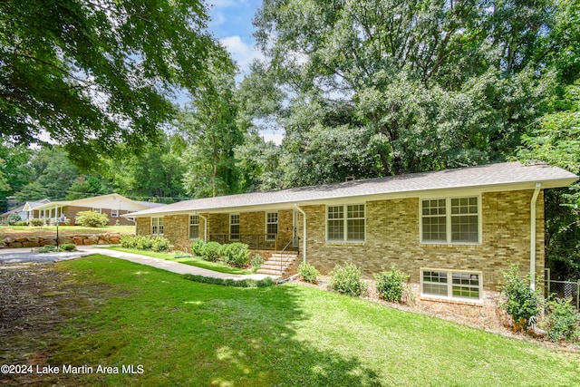 ranch-style home featuring covered porch and a front yard