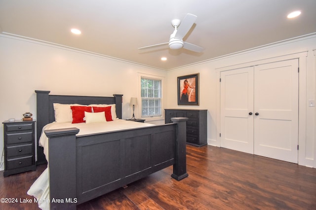 bedroom featuring ceiling fan, crown molding, dark wood-type flooring, and a closet