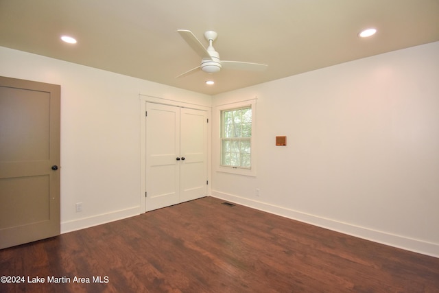 unfurnished bedroom with a closet, ceiling fan, and dark wood-type flooring