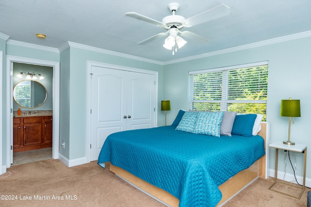 bedroom featuring light carpet, ensuite bath, ornamental molding, ceiling fan, and a closet