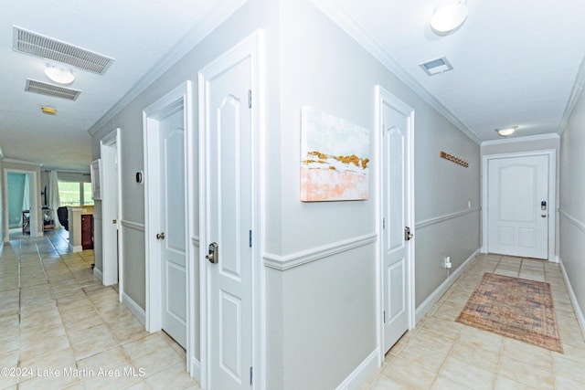 corridor with light tile patterned floors and ornamental molding