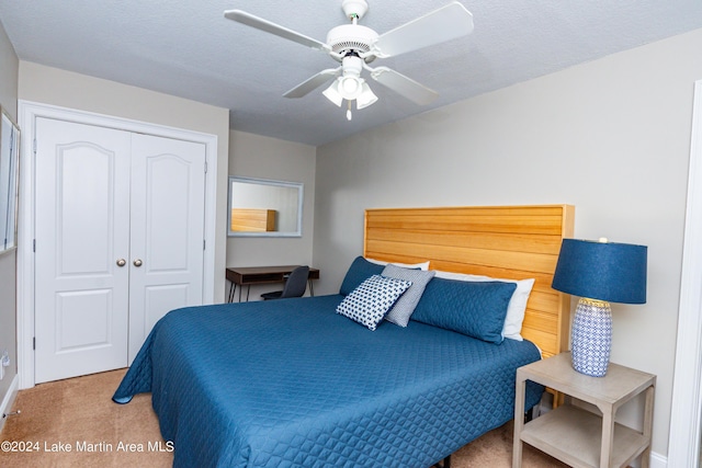 carpeted bedroom featuring ceiling fan, a closet, and a textured ceiling