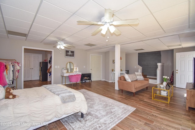 bedroom featuring wood finished floors, a drop ceiling, and ceiling fan