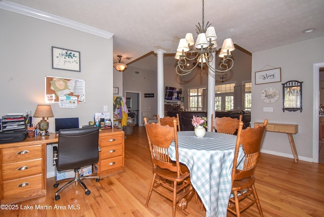 dining area with light wood-type flooring, a textured ceiling, a chandelier, and ornamental molding