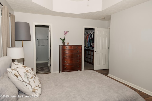 963 Birch Ct, Auburn, AL 36830 - bedroom with a walk in closet, a closet, connected bathroom, and dark wood finished floors