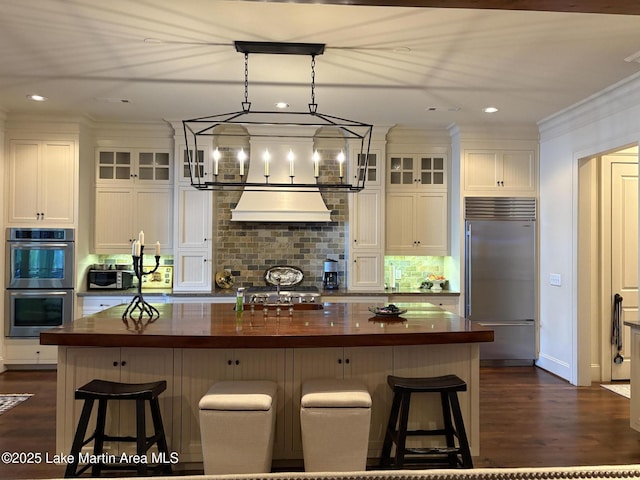 856 Windermere W Pkwy, Alexander City, AL 35010 - kitchen featuring stainless steel appliances, wood counters, under cabinet range hood, decorative backsplash, and white cabinetry