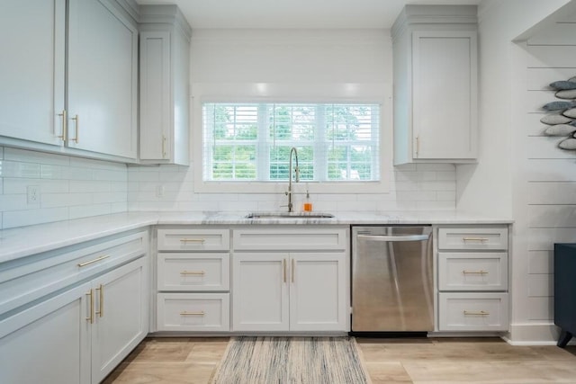 kitchen with stainless steel dishwasher, light hardwood / wood-style flooring, sink, and tasteful backsplash