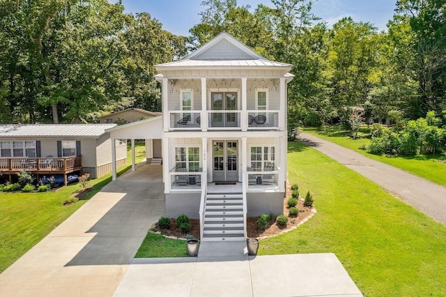 view of outdoor structure featuring a lawn, french doors, a porch, and a carport