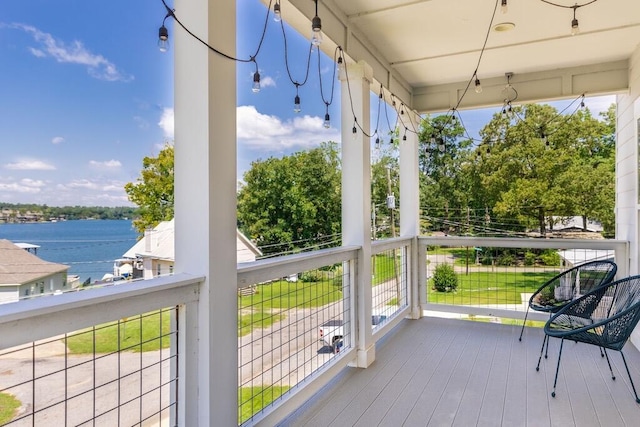 sunroom featuring a water view