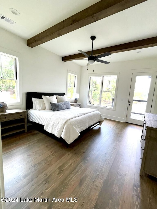 unfurnished bedroom with multiple windows, beam ceiling, dark hardwood / wood-style floors, and ceiling fan