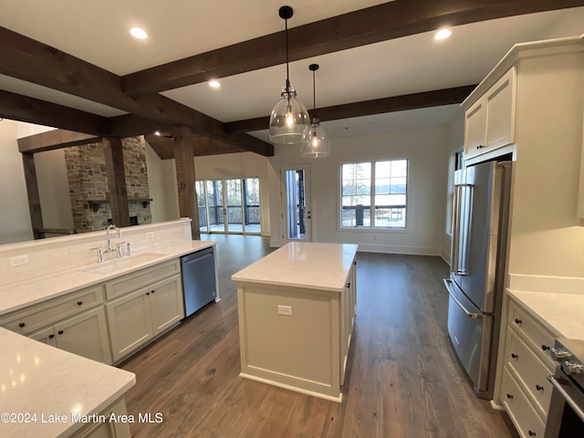 kitchen with stainless steel appliances, a center island, sink, and white cabinets