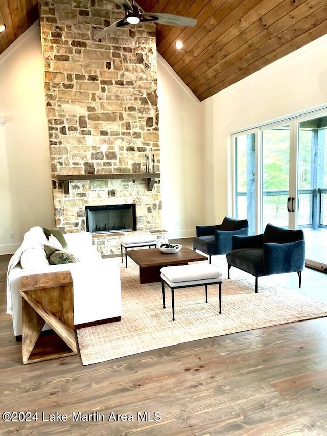 living room featuring a stone fireplace, high vaulted ceiling, wood-type flooring, wood ceiling, and french doors